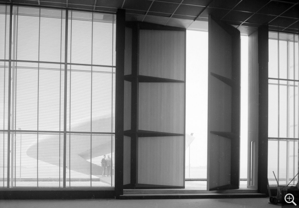 Vue intérieure vers la grande porte en aluminium conçue par Jean Prouvé, 1961. © Centre Pompidou, bibliothèque Kandinsky, fonds Cardot-Joly / Pierre Joly - Véra Cardot